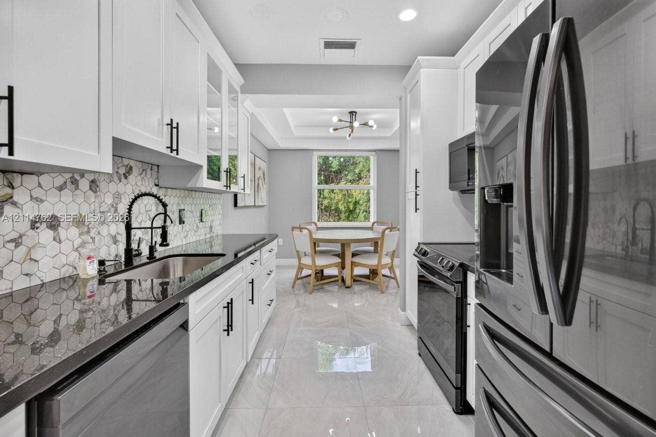 662 NW 170th Terrace, Pembroke Pines, FL 33028 Kitchen featuring white Shaker-style cabinetry, dark stone-finish countertops, geometric tile backsplash, stainless steel appliances, and tile flooring