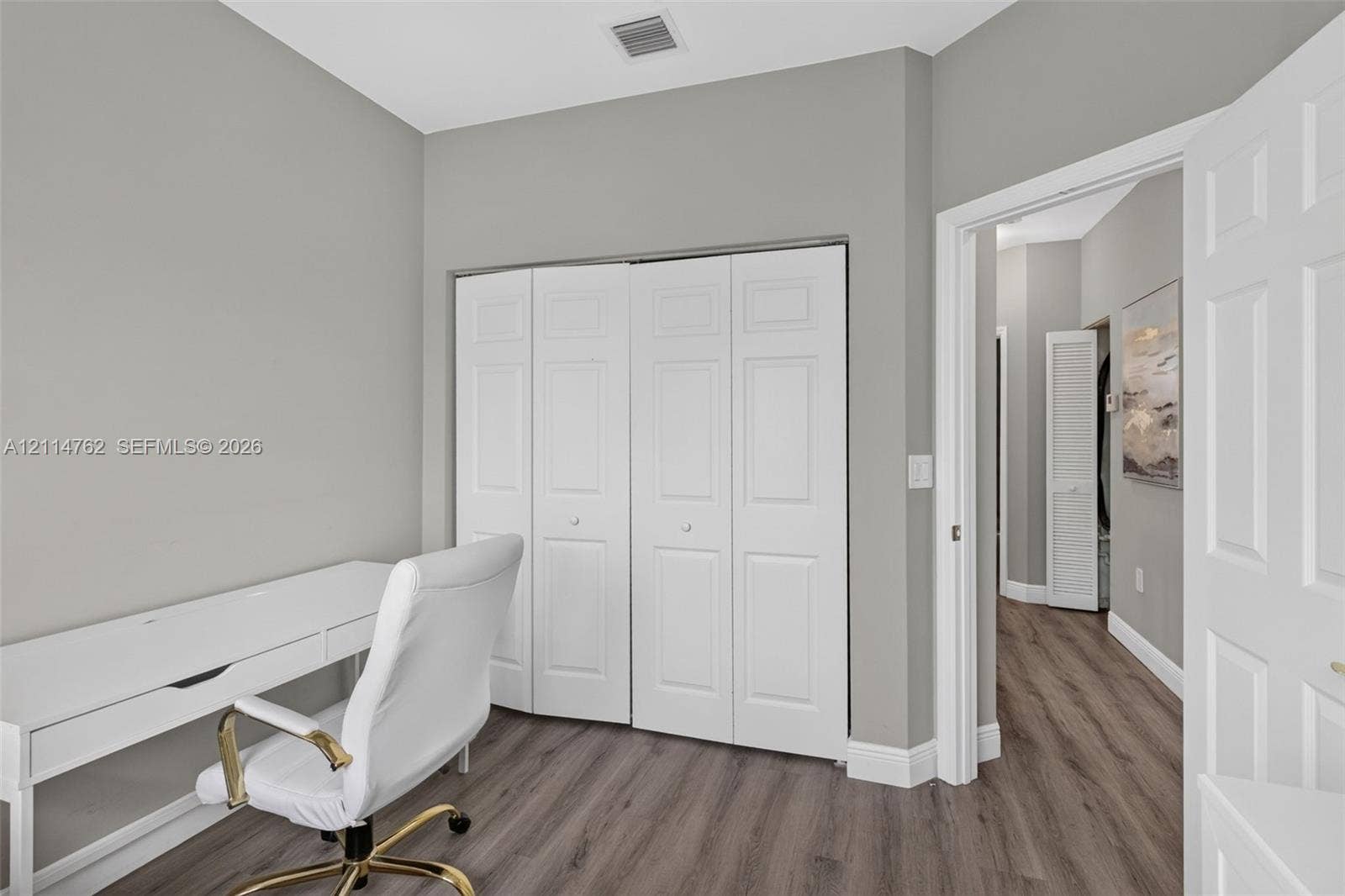 662 NW 170th Terrace, Pembroke Pines, FL 33028 Neutral-toned walls featuring wood-finish flooring and a white paneled closet door