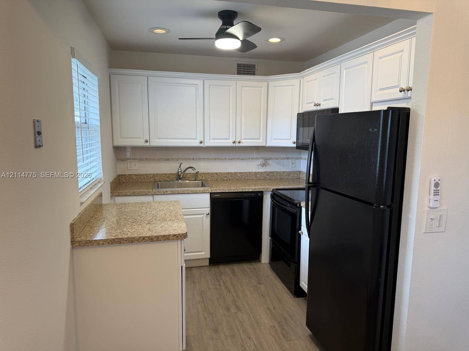 653 N Saxony N, #653, Delray Beach, FL 33446 Kitchen featuring white cabinetry, stone-finish countertops, black appliances, recessed lighting, and wood-finish flooring