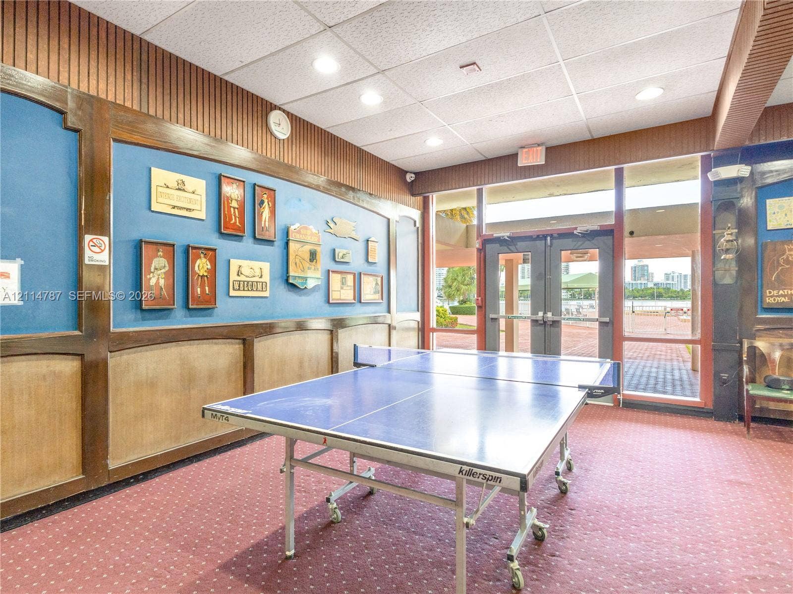 Interior space featuring decorative wood wainscoting, integrated wall paneling, recessed lighting, and full-length glass paneled double doors