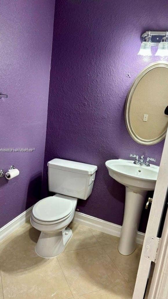 932 Falling Water Road, Weston, Weston, FL 33326 Pedestal sink with dual-handle chrome faucet, oval wall-mounted mirror, two-piece toilet, and tile flooring
