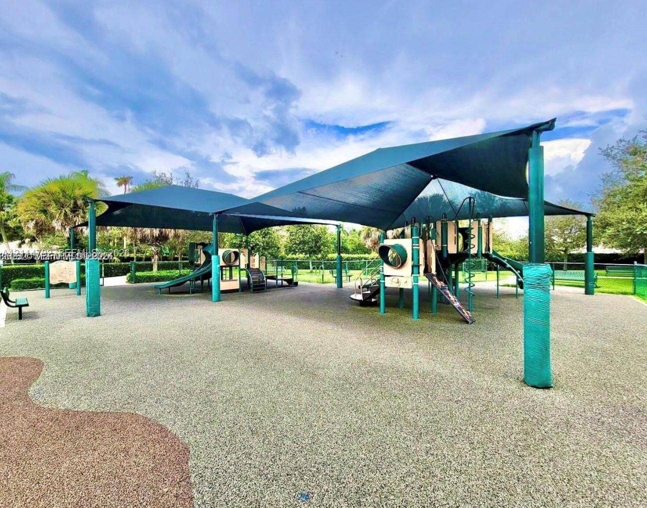 932 Falling Water Road, Weston, Weston, FL 33326 Recreational area featuring a large overhead tensioned canopy, multi-component play structure, rubberized surfacing, and perimeter landscaping