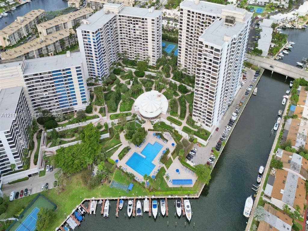 2500 Parkview Drive, #811, Hallandale Beach, Hallandale Beach, FL 33009 High-rise residential complex featuring a central swimming pool, landscaped gardens, tennis courts, and private boat slips along a waterway
