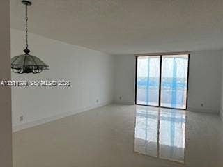 2500 Parkview Drive, #811, Hallandale Beach, Hallandale Beach, FL 33009 Open-concept interior featuring polished tile flooring, floor-to-ceiling sliding glass doors, and a decorative pendant light fixture