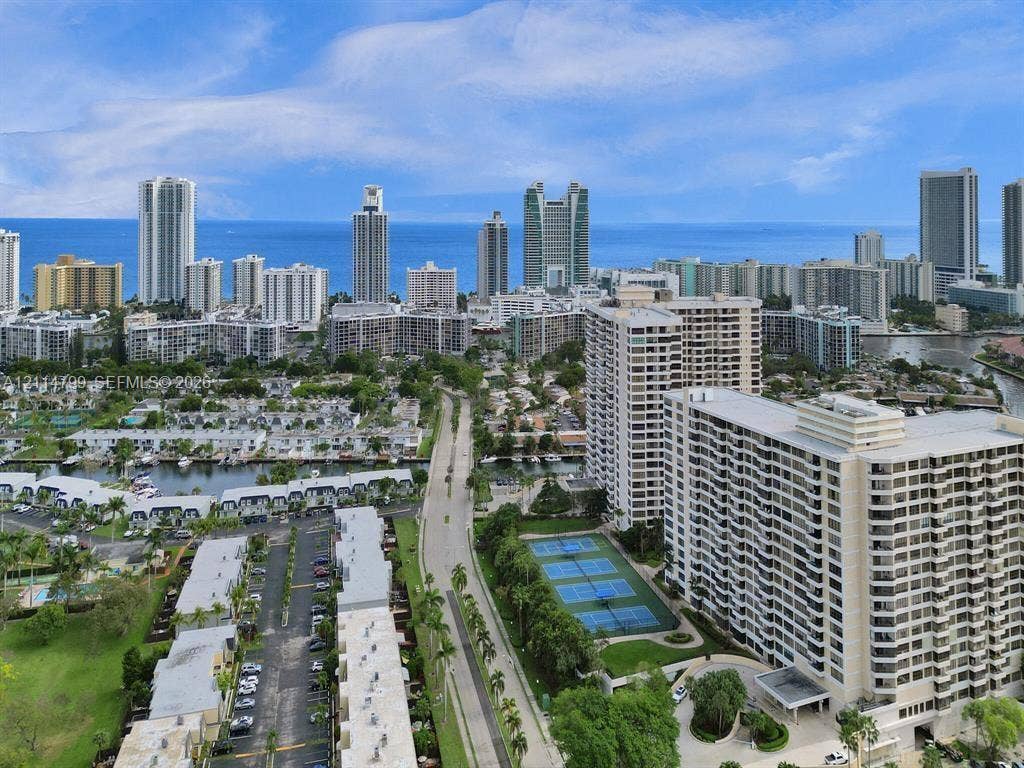 2500 Parkview Drive, #811, Hallandale Beach, Hallandale Beach, FL 33009 Aerial perspective featuring coastal urban surroundings, a multi-story high-rise complex, tennis courts, and mature landscaping
