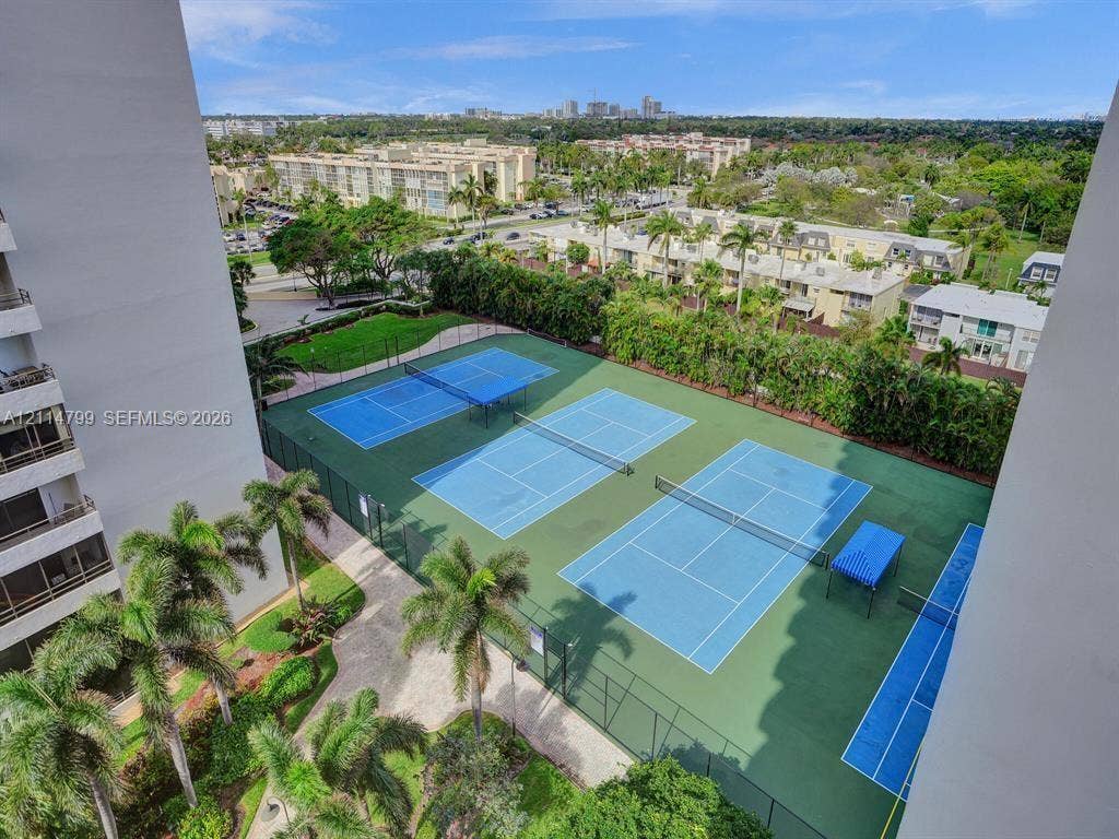 2500 Parkview Drive, #811, Hallandale Beach, Hallandale Beach, FL 33009 Multi-court tennis facility featuring fenced perimeters, paved walkways, and mature palm landscaping