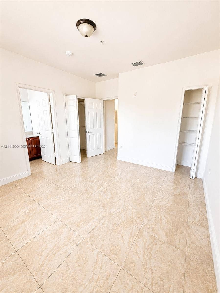 18130 NW 59th Avenue, #201, Hialeah, Hialeah, FL 33015 Room with tile flooring, two closets with bi-fold doors, a single-light dome ceiling fixture, and a white six-panel door