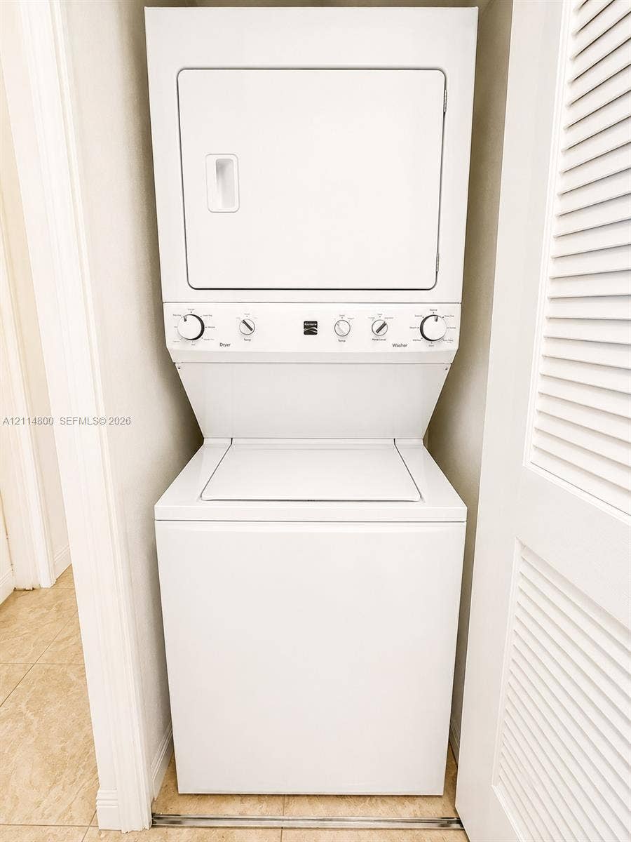 18130 NW 59th Avenue, #201, Hialeah, Hialeah, FL 33015 White stackable laundry unit enclosed within a closet featuring louvered doors