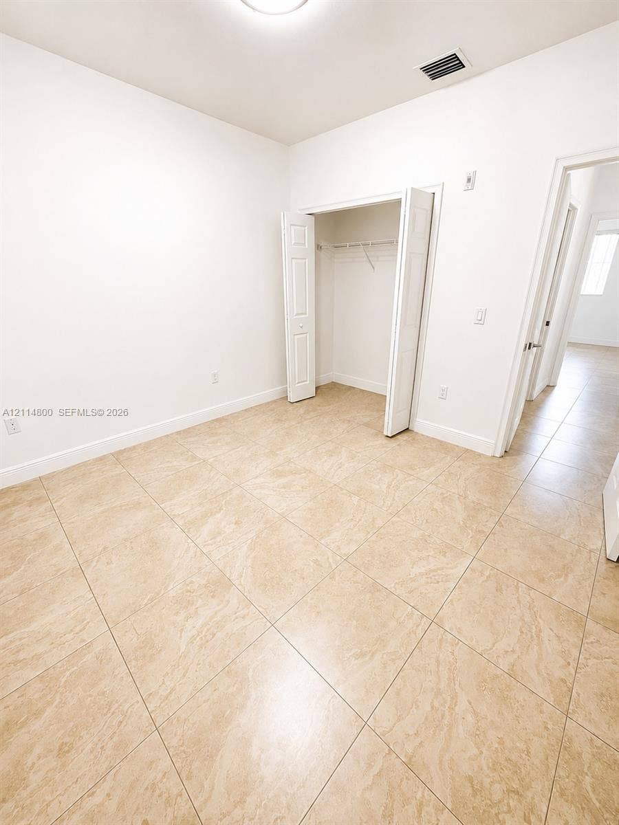 18130 NW 59th Avenue, #201, Hialeah, Hialeah, FL 33015 Neutral-toned tile flooring, white wall finish, and a closet with bifold doors