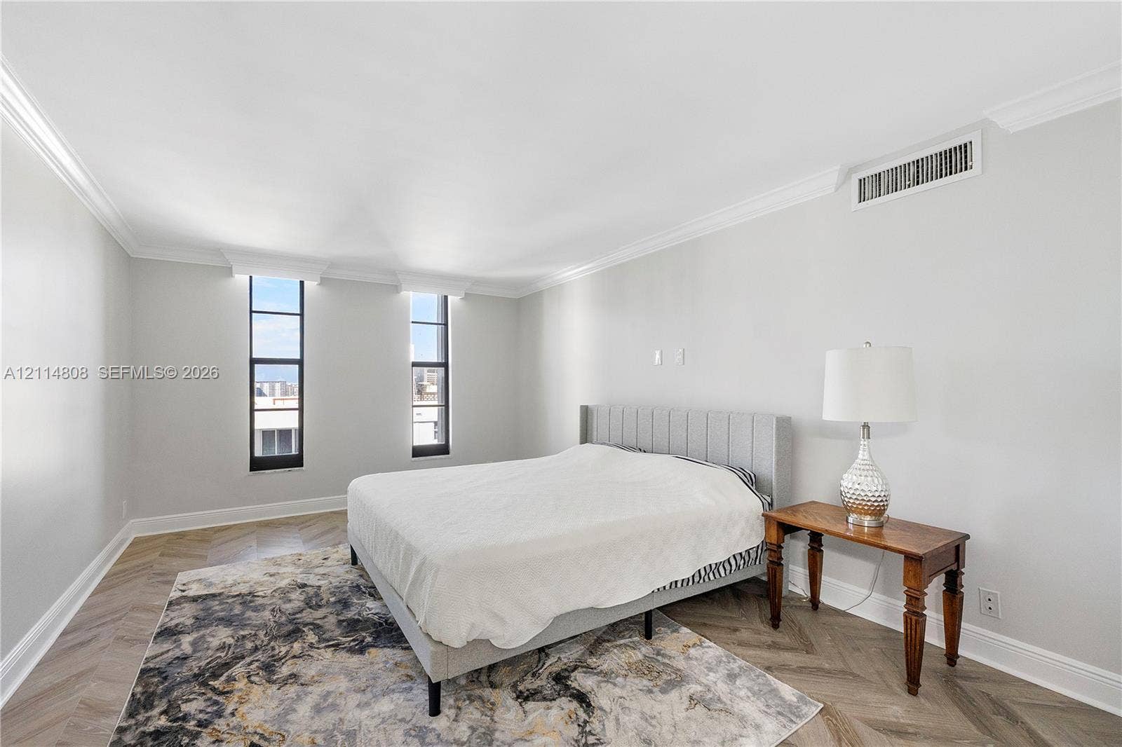 1000 S Ocean Boulevard, #16P, Pompano Beach, Pompano Beach, FL 33062 Herringbone pattern wood-finish flooring, crown molding, and two tall vertical windows with dark metal frames