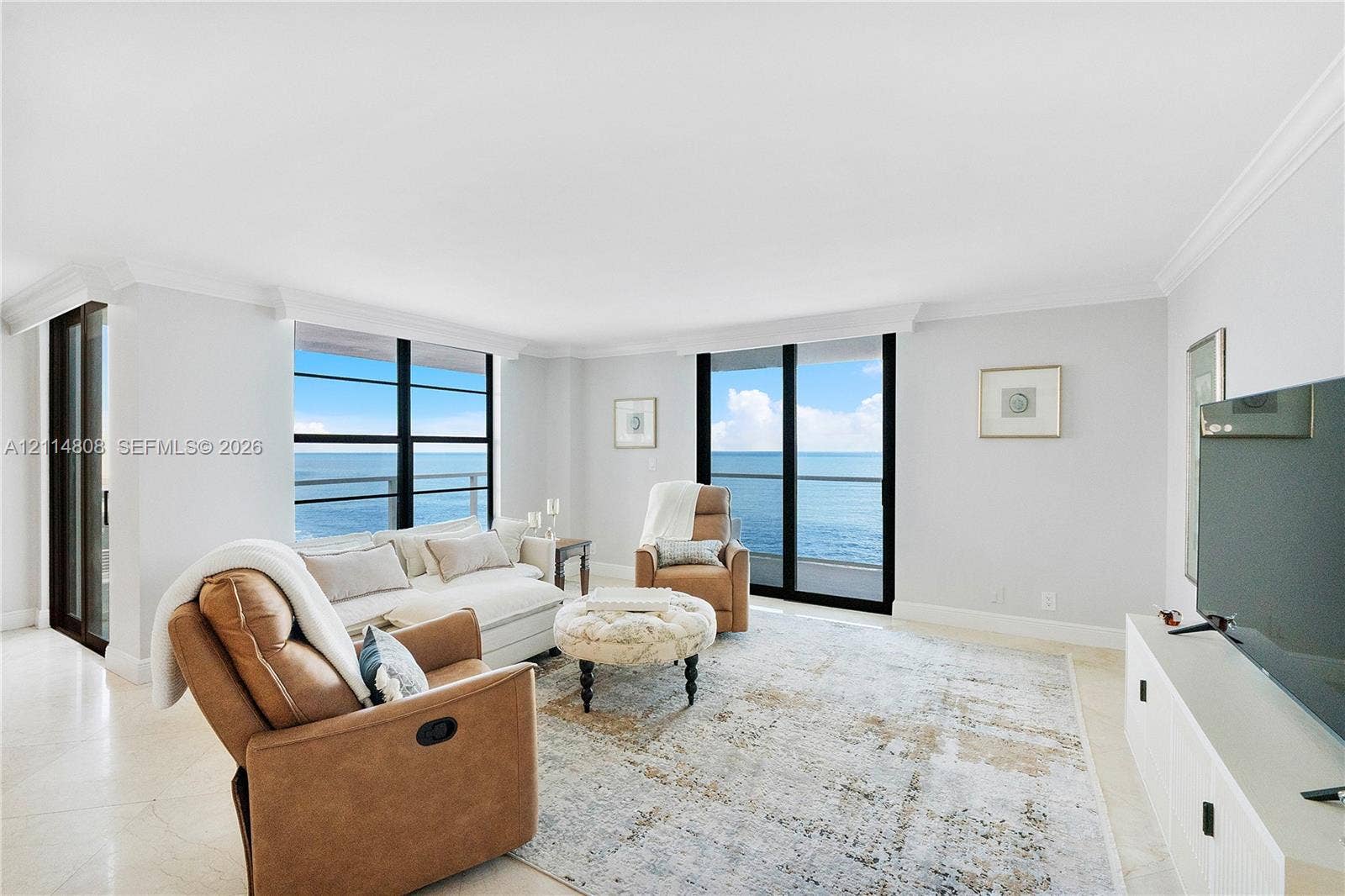 1000 S Ocean Boulevard, #16P, Pompano Beach, Pompano Beach, FL 33062 Living area featuring large-format tile flooring, crown molding, and floor-to-ceiling windows with direct ocean exposure