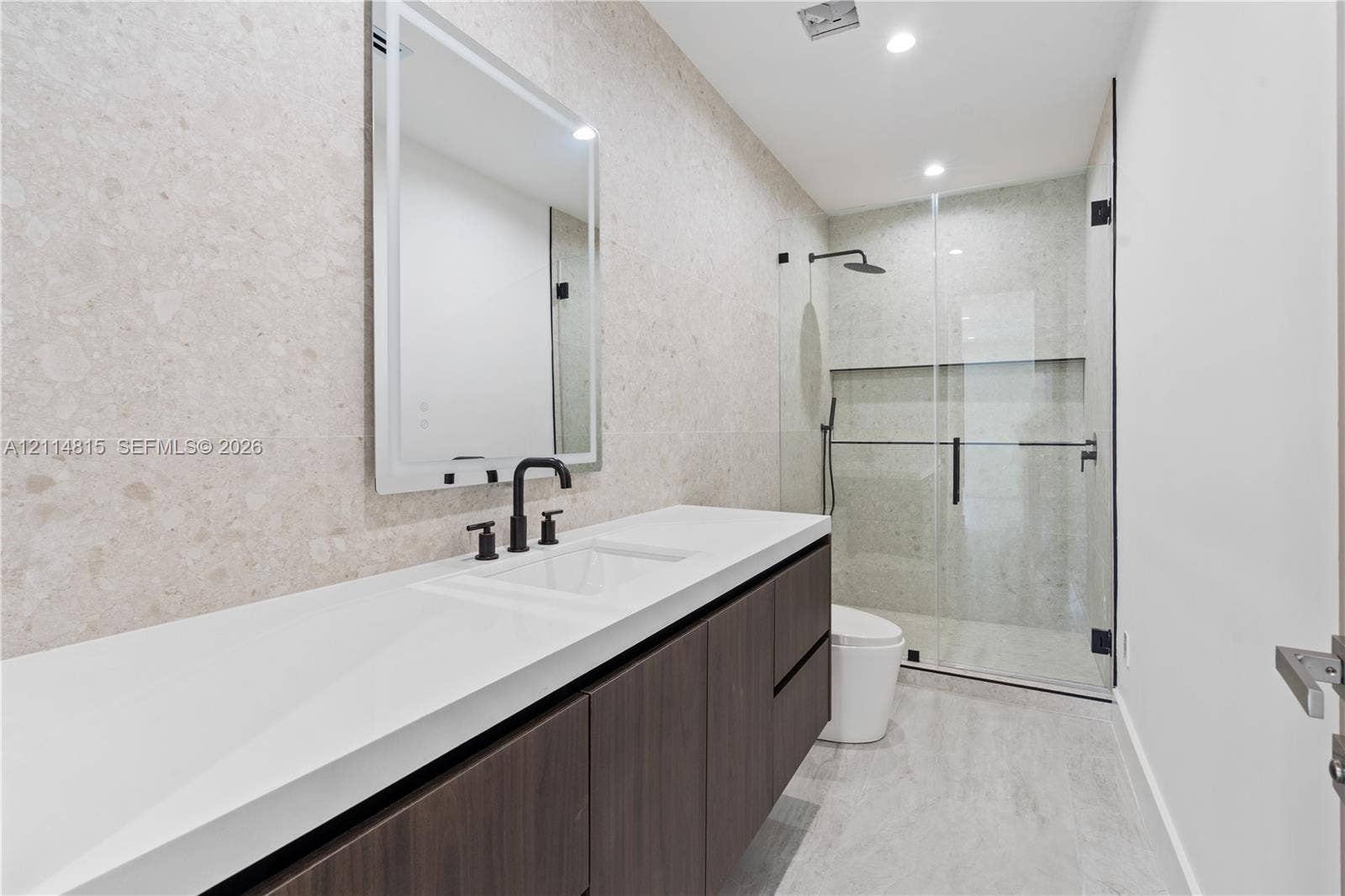 Floating dark wood-finish vanity with a rectangular sink, topped by a white countertop and a framed mirror