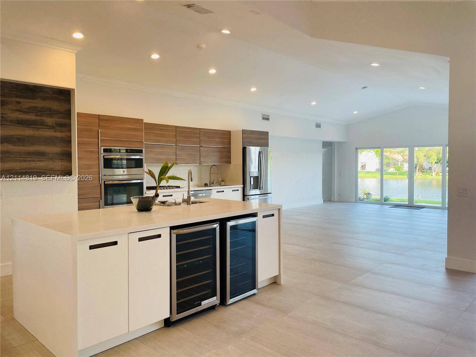 1952 Water Ridge Drive, #1952, Weston, Weston, FL 33326 Kitchen featuring horizontal wood-grain cabinetry, quartz countertops, built-in dual beverage refrigerators, stainless steel double wall ovens, and porcelain tile flooring
