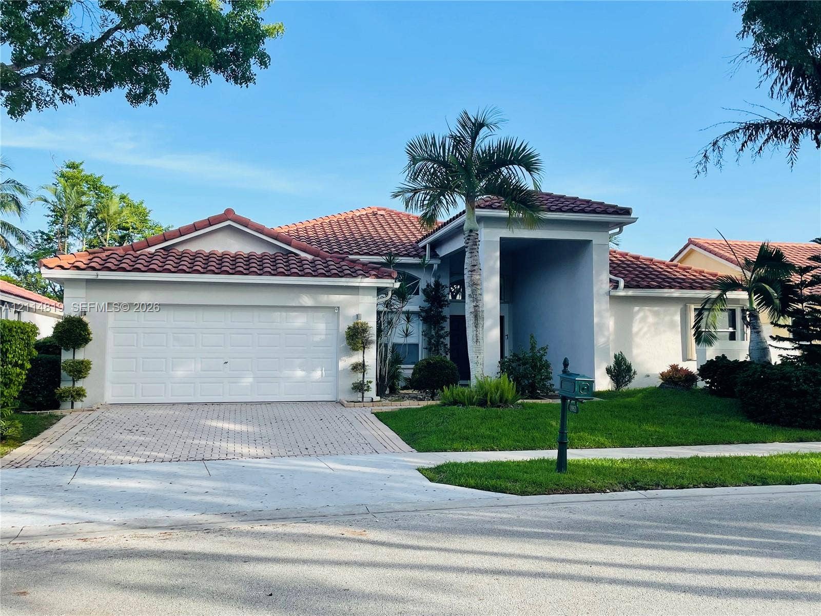 1952 Water Ridge Drive, #1952, Weston, Weston, FL 33326 Stucco exterior featuring a multi-gabled tile roof, paver driveway, attached two-car garage, and manicured landscaping