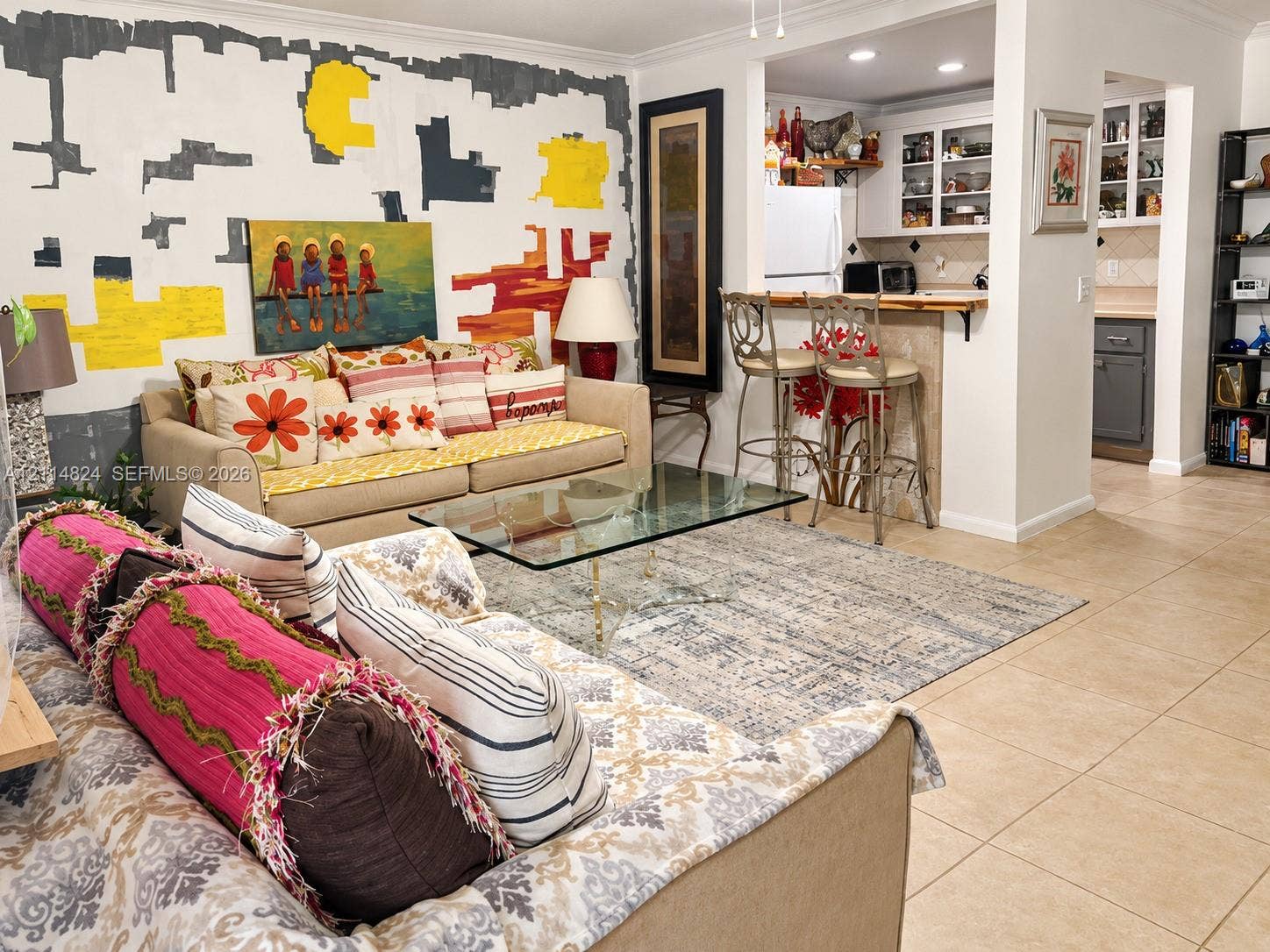 563 Durham T, #563, Deerfield Beach, FL 33442 Open-concept interior featuring light-toned tile flooring, built-in kitchen cabinetry with integrated glass-front display storage, and a pass-through breakfast bar with a tile-faced counter