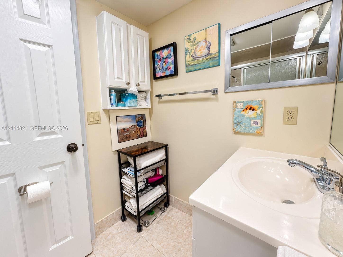 563 Durham T, #563, Deerfield Beach, FL 33442 Bathroom vanity featuring a white cabinet base, integrated sink with a chrome-finished faucet, wall-mounted medicine cabinet with a mirrored front, and additional upper storage cabinetry