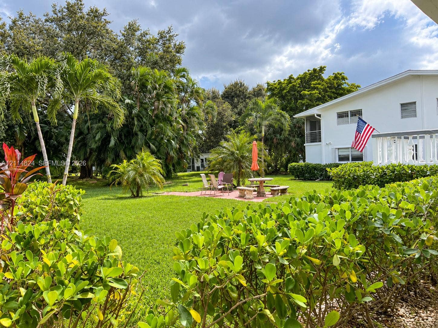 563 Durham T, #563, Deerfield Beach, FL 33442 Expansive grounds featuring a manicured lawn, established palm trees, a brick paver patio, and low-maintenance perimeter shrubbery