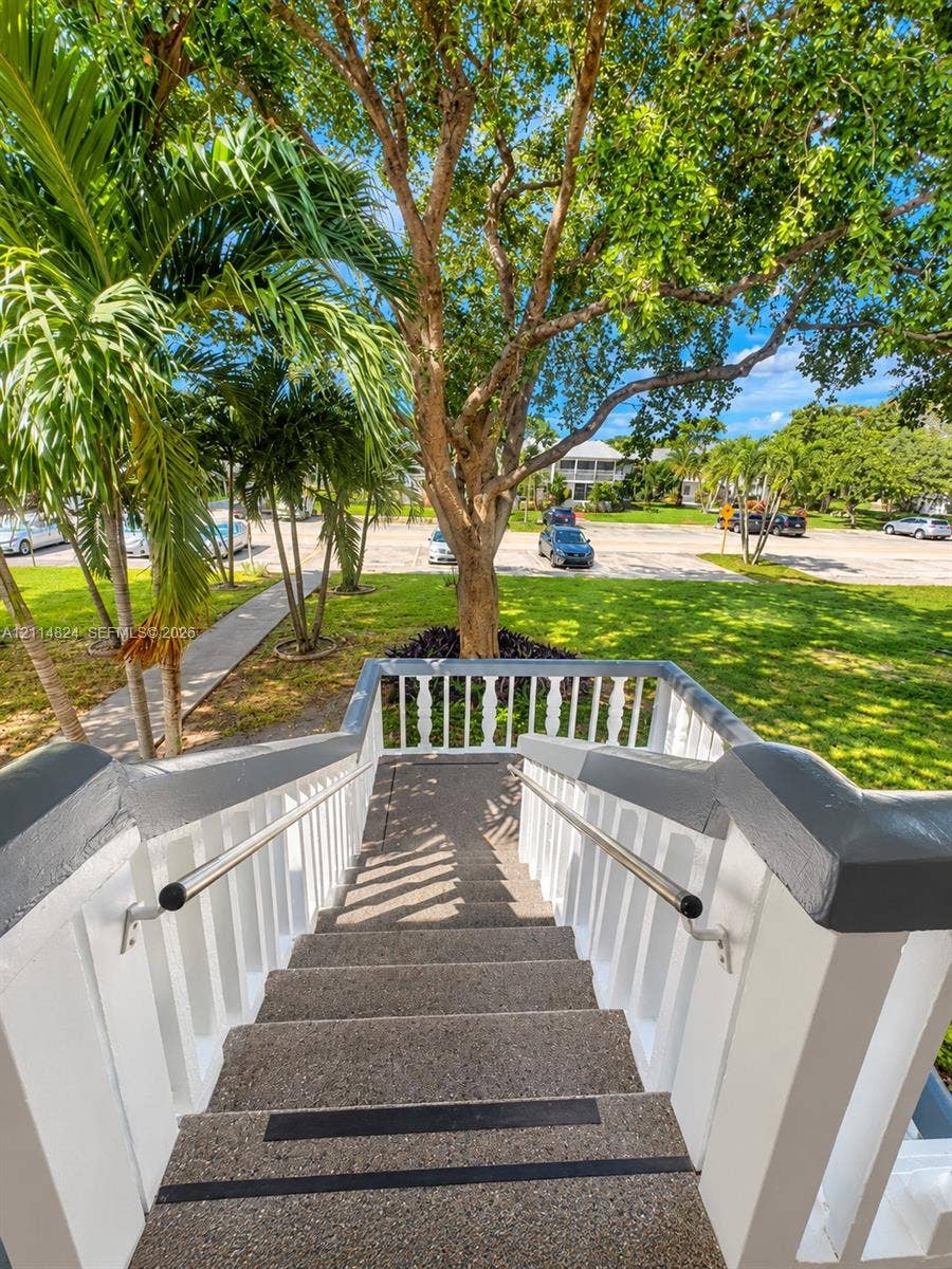 563 Durham T, #563, Deerfield Beach, FL 33442 Exterior staircase featuring aggregate treads with integrated anti-slip strips, white balustrades, painted railings, and metal handrails