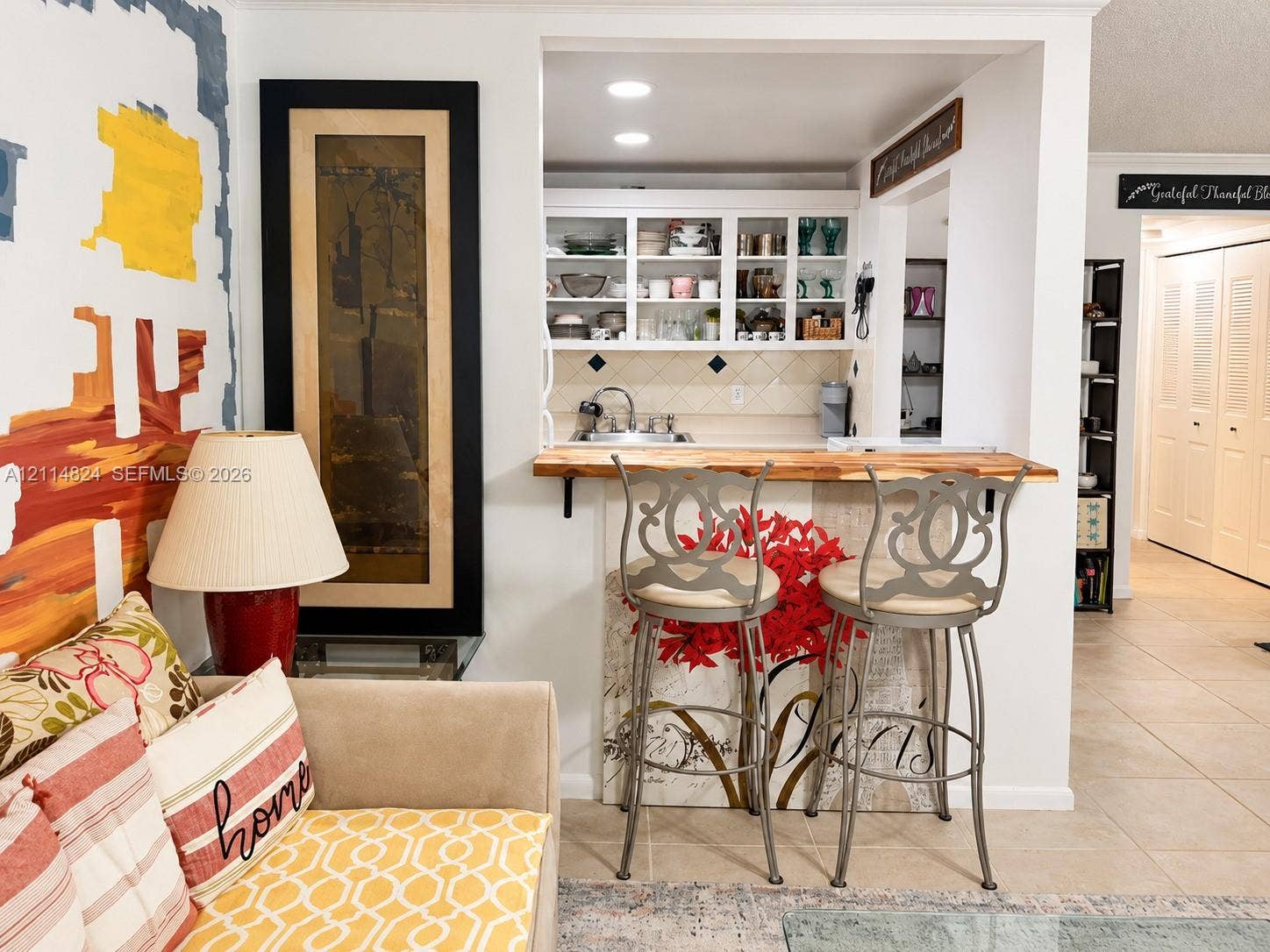 563 Durham T, #563, Deerfield Beach, FL 33442 Kitchen pass-through featuring a wood-topped breakfast bar, white cabinetry with glass-panel doors, tile backsplash, recessed lighting, and a built-in sink