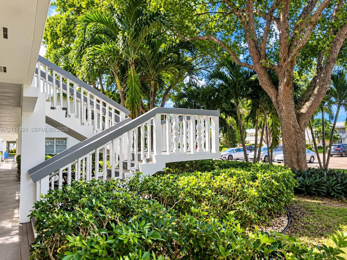563 Durham T, #563, Deerfield Beach, FL 33442 Exterior staircase featuring white balustrades, concrete steps, and mature palm trees