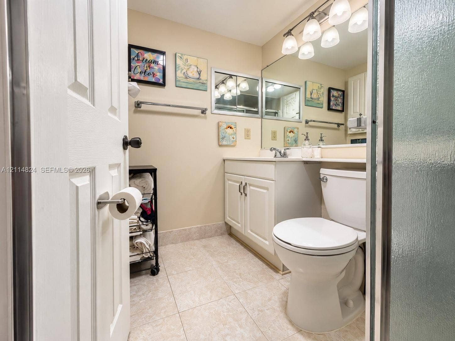 563 Durham T, #563, Deerfield Beach, FL 33442 Bathroom featuring a vanity with white cabinetry, a large wall-mounted mirror, ceramic tile flooring, and a five-light overhead fixture