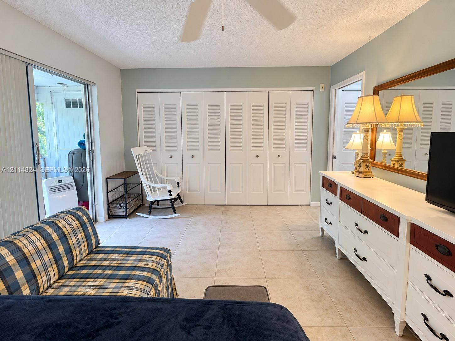 563 Durham T, #563, Deerfield Beach, FL 33442 Neutral ceramic tile flooring, floor-to-ceiling louvered closet doors, and sliding glass patio door