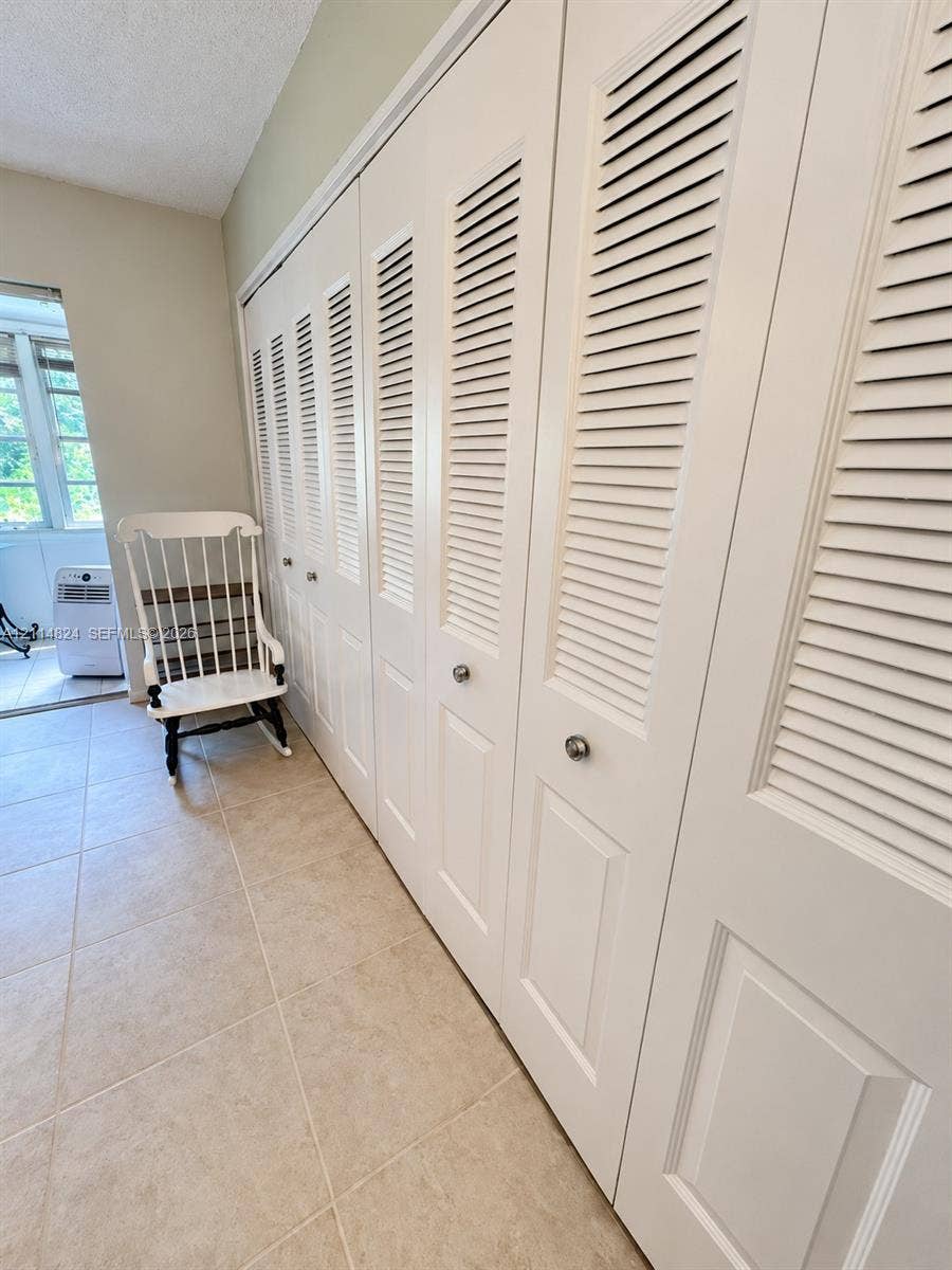 563 Durham T, #563, Deerfield Beach, FL 33442 Extensive floor-to-ceiling storage featuring white louvered bifold doors with metallic hardware and neutral-tone ceramic tile flooring
