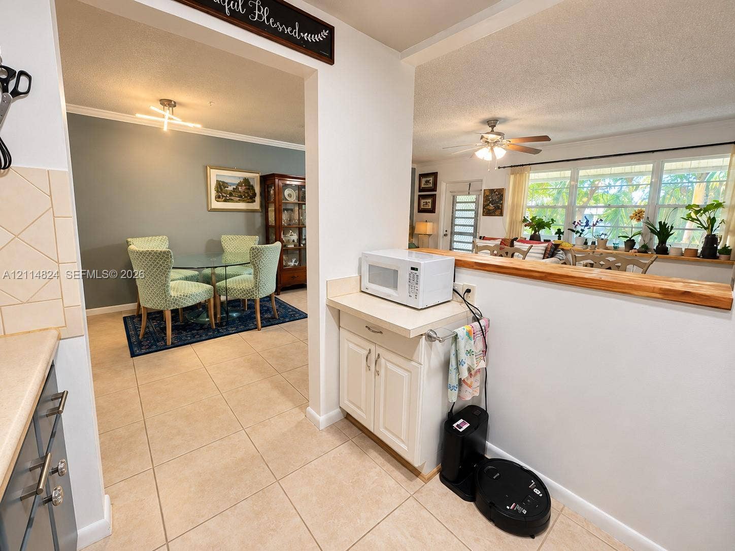 563 Durham T, #563, Deerfield Beach, FL 33442 Kitchen featuring tile flooring, neutral cabinetry, and a natural wood-topped pass-through counter