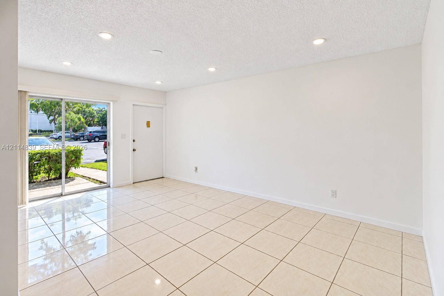 3000 NW 5th Terrace, #131, Pompano Beach, Pompano Beach, FL 33064 Interior featuring neutral tile flooring, recessed ceiling lighting, and sliding glass door access to the exterior