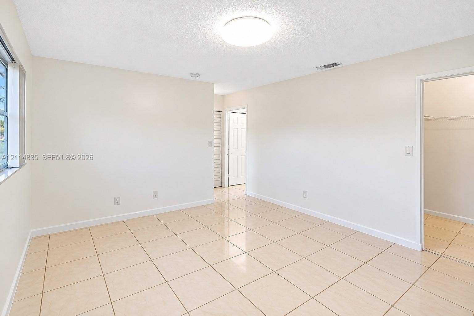3000 NW 5th Terrace, #131, Pompano Beach, Pompano Beach, FL 33064 Neutral interior featuring large-format tile flooring, textured ceiling, flush-mount lighting, and a walk-in closet