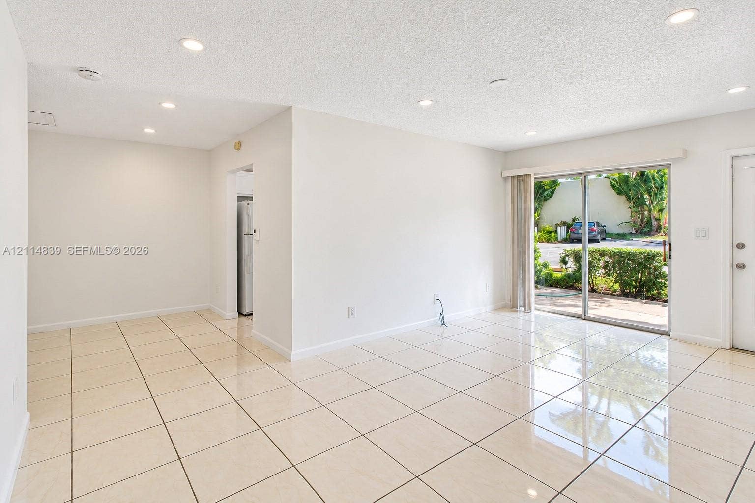 3000 NW 5th Terrace, #131, Pompano Beach, Pompano Beach, FL 33064 Living area featuring large-format tile flooring, recessed lighting, and a sliding glass door