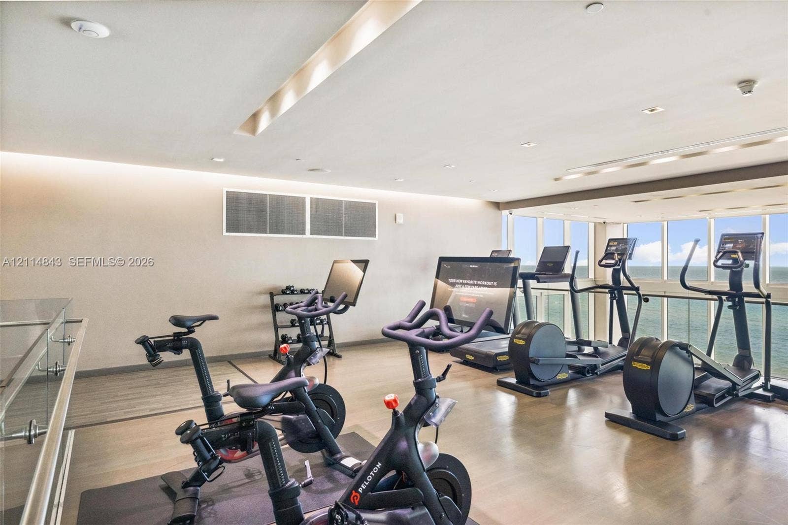 Fitness center featuring wood-finish flooring, recessed ceiling lighting, and floor-to-ceiling windows