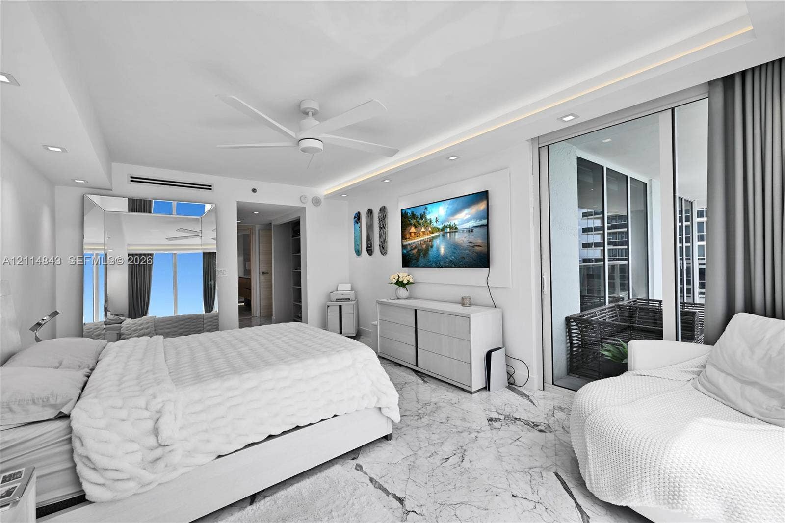 Stone flooring, tray ceiling with recessed lighting, floor-to-ceiling glass sliding doors, and ceiling fan
