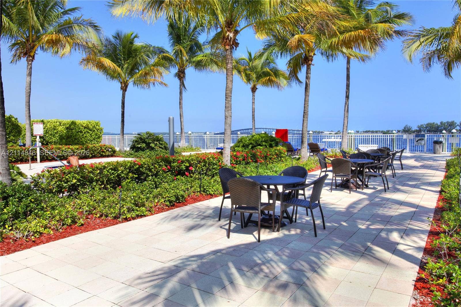 2101 Brickell Avenue, #601, Miami, Miami, FL 33129 Waterfront patio featuring stone paver flooring, manicured landscaping, and mature palm trees