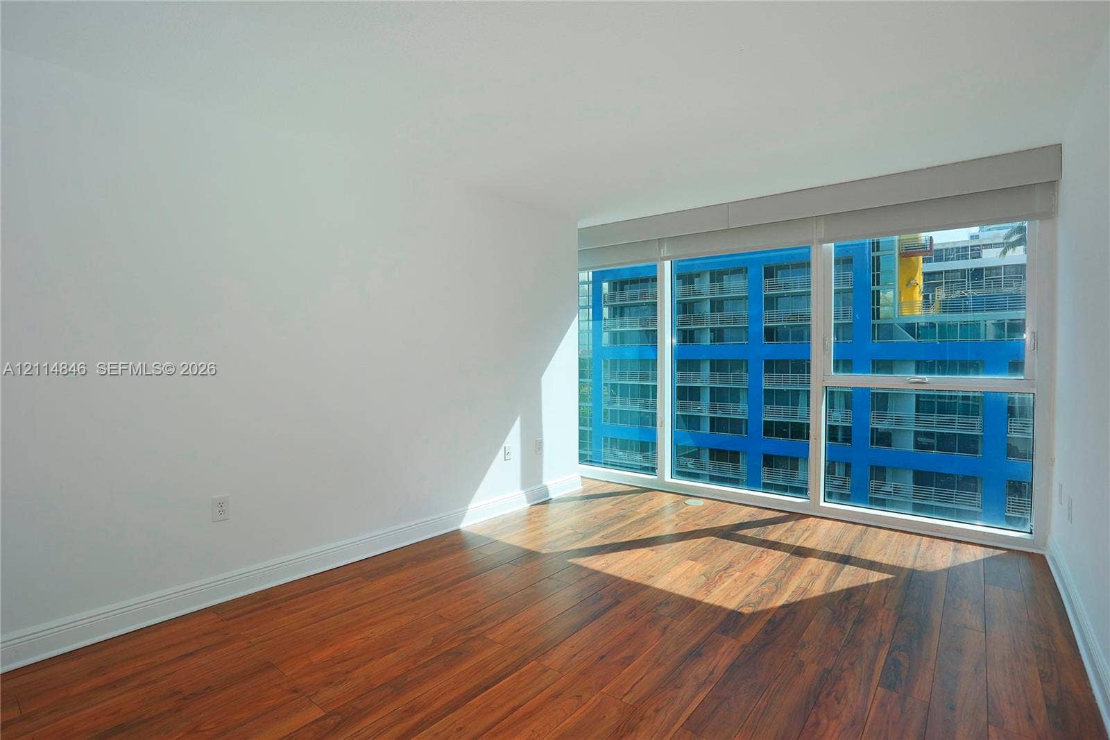 2101 Brickell Avenue, #601, Miami, Miami, FL 33129 Interior space featuring floor-to-ceiling windows, wood-finish flooring, and neutral wall tones
