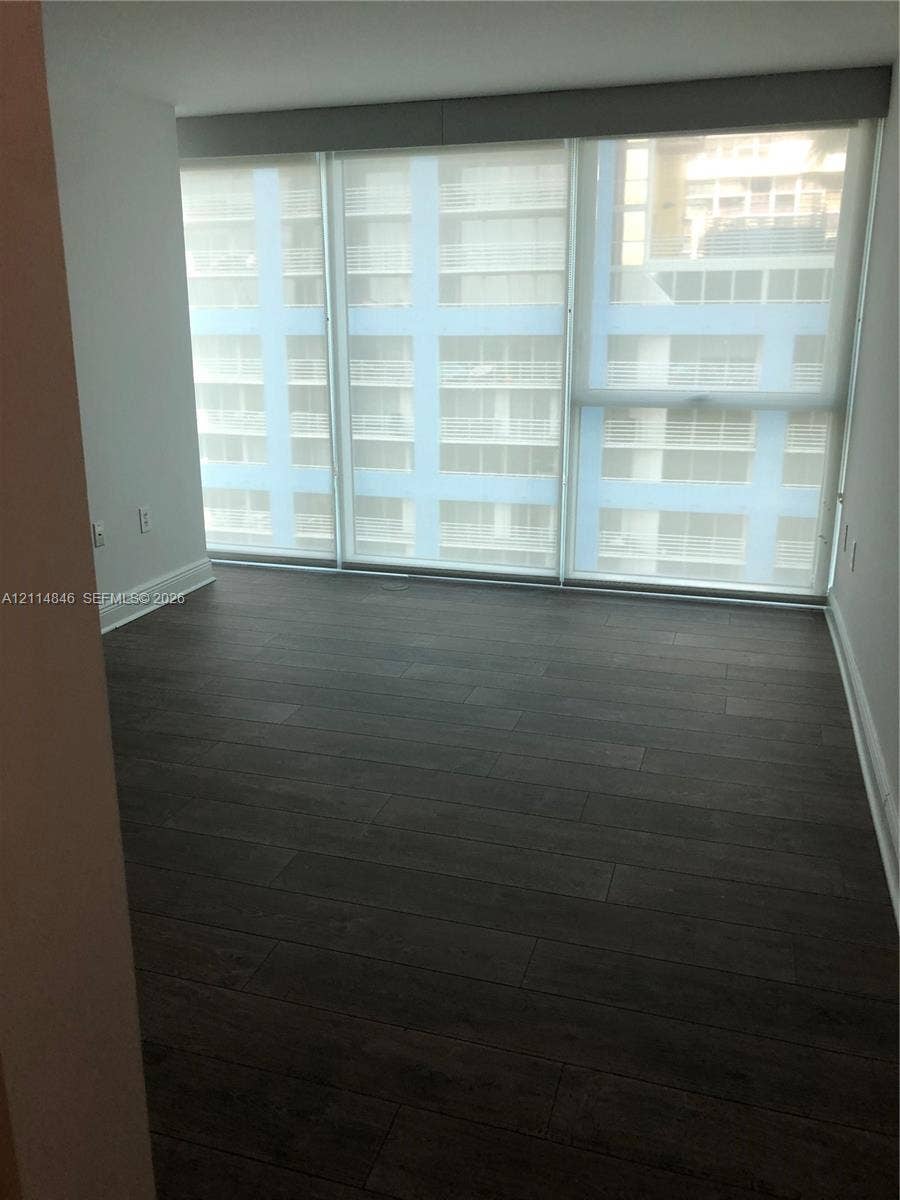 2101 Brickell Avenue, #601, Miami, Miami, FL 33129 Floor-to-ceiling windows with roller shades and dark wood-finish flooring