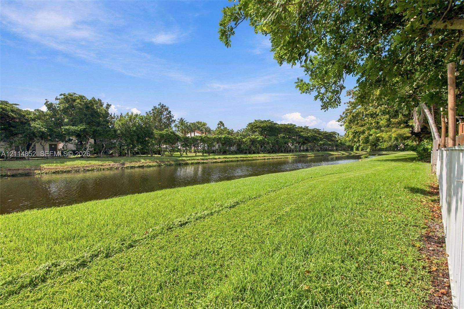 10780 NW 10th Street, Plantation, FL 33322 Waterfront parcel featuring extensive lawn, mature trees, and canal frontage