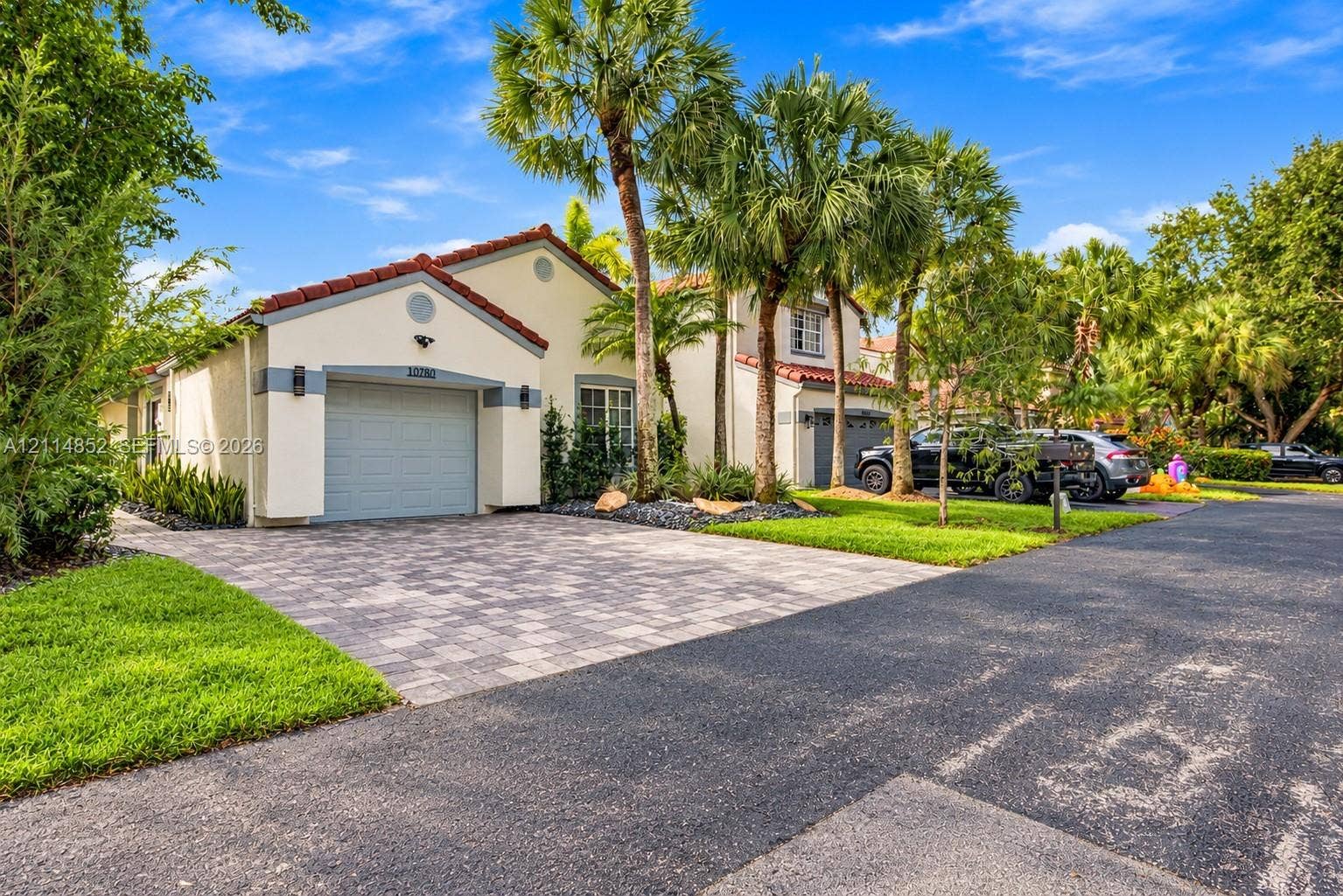 10780 NW 10th Street, Plantation, FL 33322 Stucco exterior featuring a red tile roof, single-car garage, and paver driveway