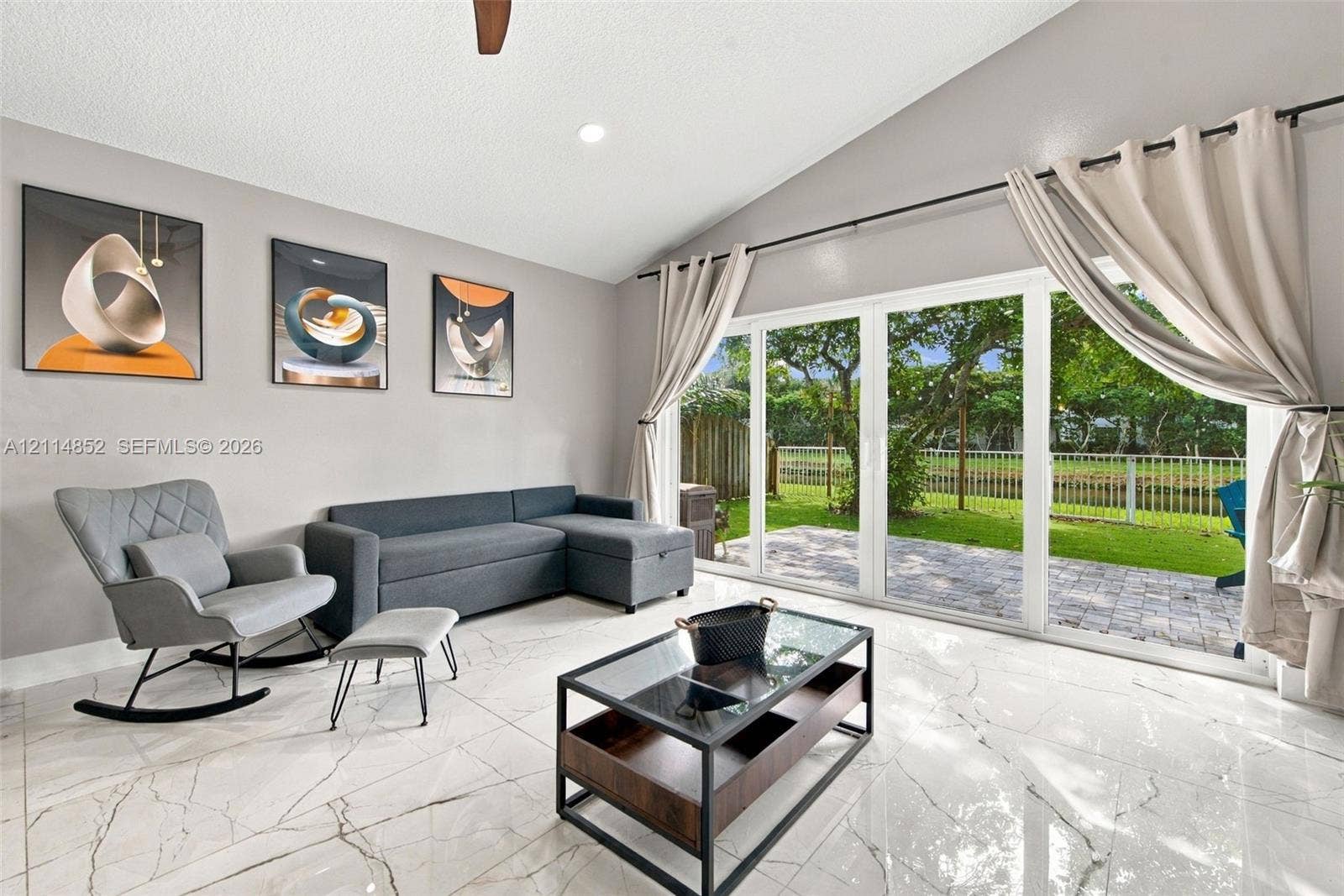 10780 NW 10th Street, Plantation, FL 33322 Vaulted ceiling, polished stone-finish flooring, and expansive glass sliding doors providing entry to the outdoor patio