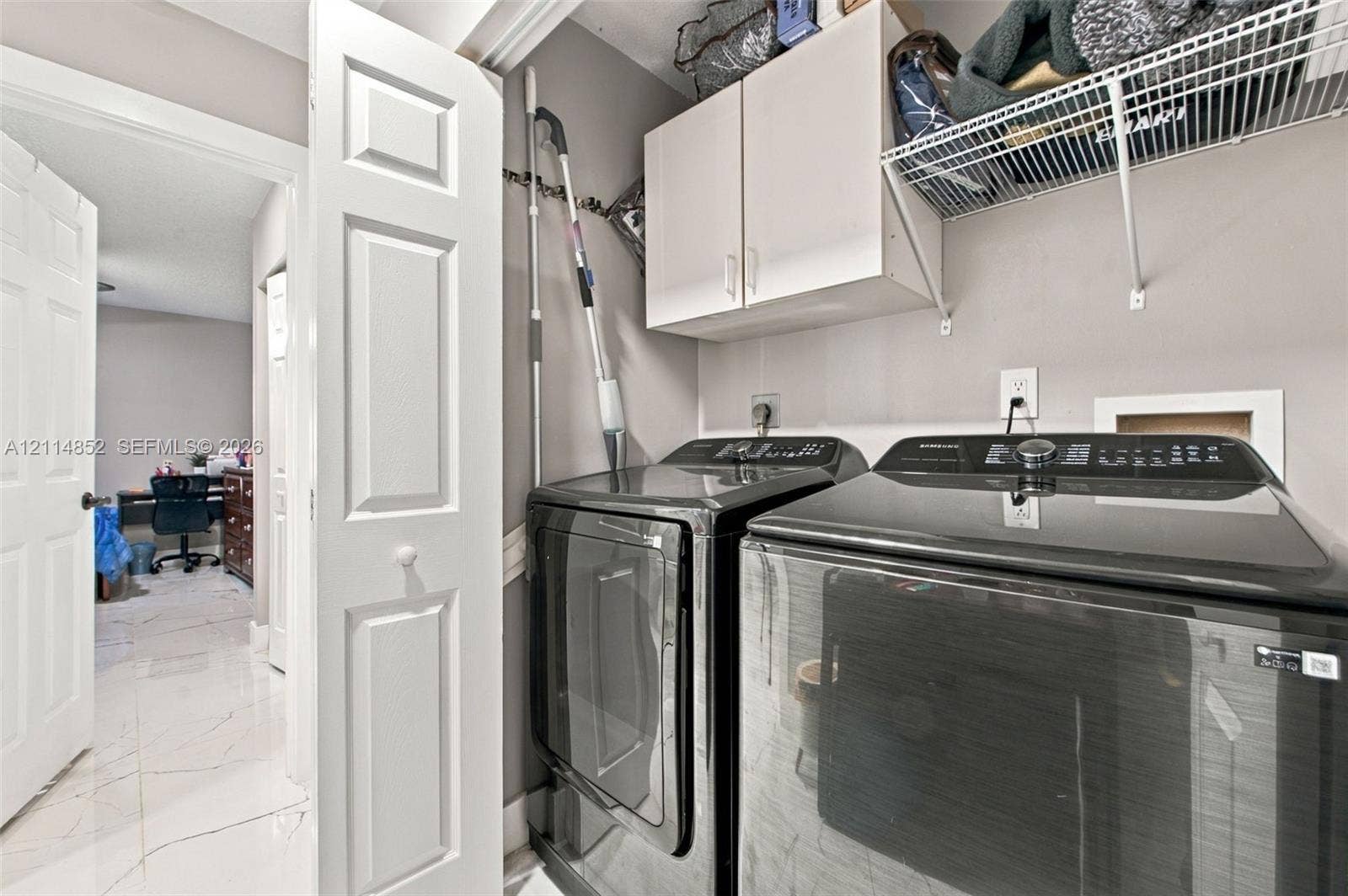 10780 NW 10th Street, Plantation, FL 33322 Laundry area featuring white cabinetry, wire shelving, and neutral wall tones