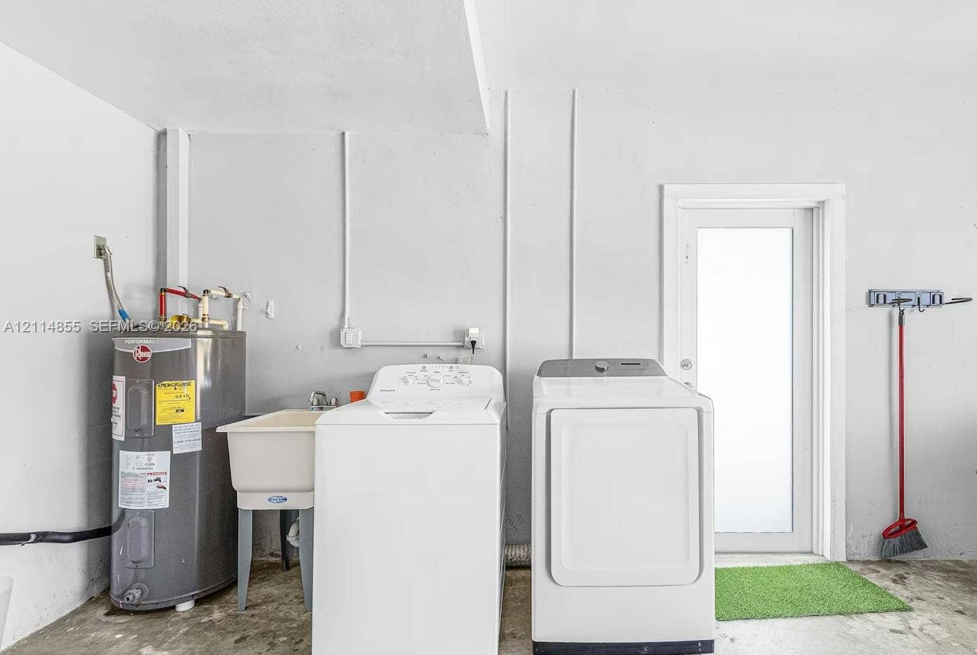 802 Montclair Court, Cape Coral, FL 33904 Utility area featuring a floor-mounted water heater, a basin sink with a chrome faucet, and exterior door access