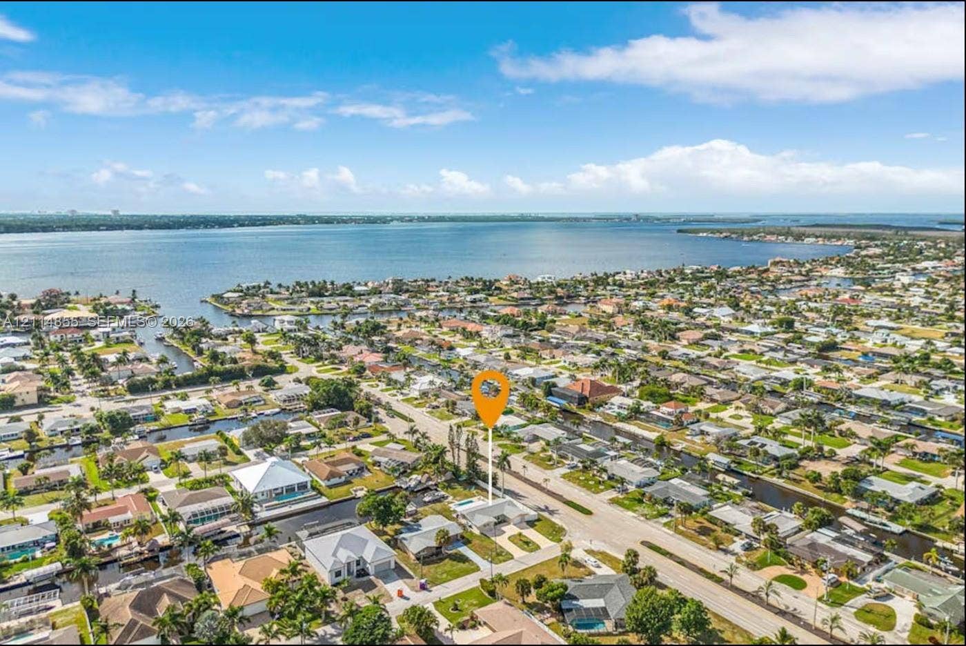 802 Montclair Court, Cape Coral, FL 33904 Aerial perspective of a coastal residential property featuring a backyard swimming pool and direct proximity to canal waterways