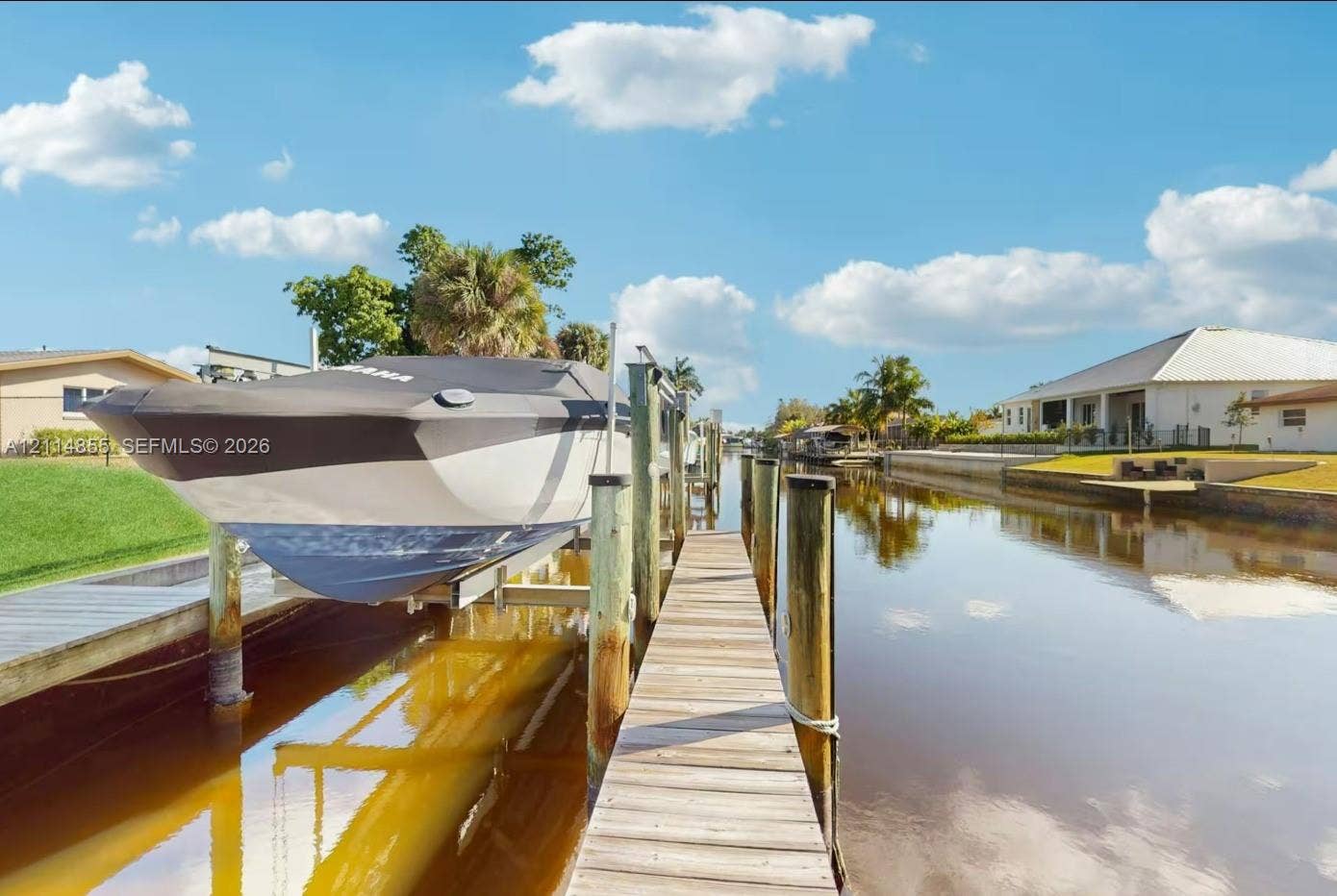 802 Montclair Court, Cape Coral, FL 33904 Private waterfront dock featuring wooden decking, sturdy pilings, and a mechanical boat lift