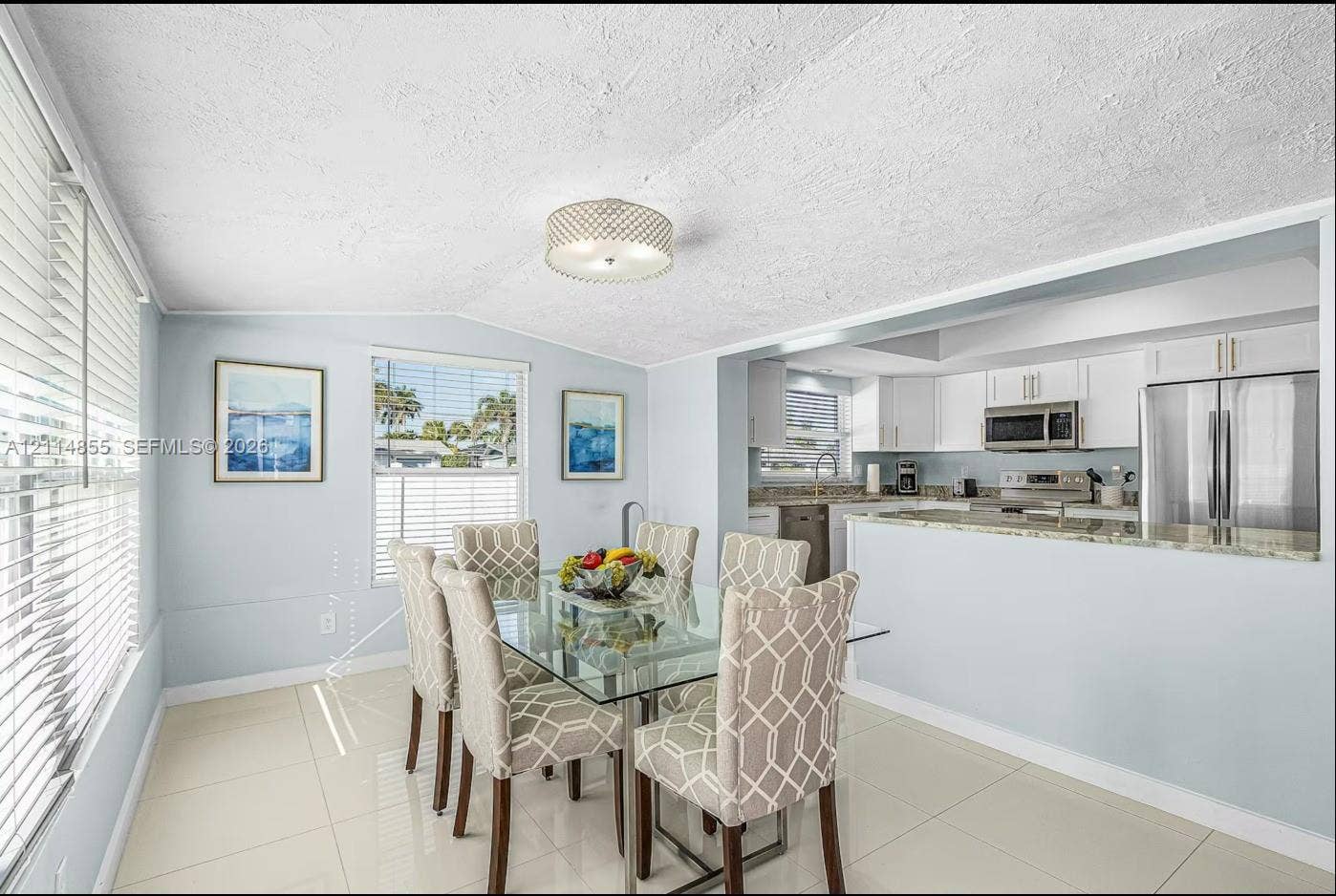 802 Montclair Court, Cape Coral, FL 33904 Dining area featuring large-format tile flooring, a semi-flush mount drum light fixture, and windows with horizontal blinds