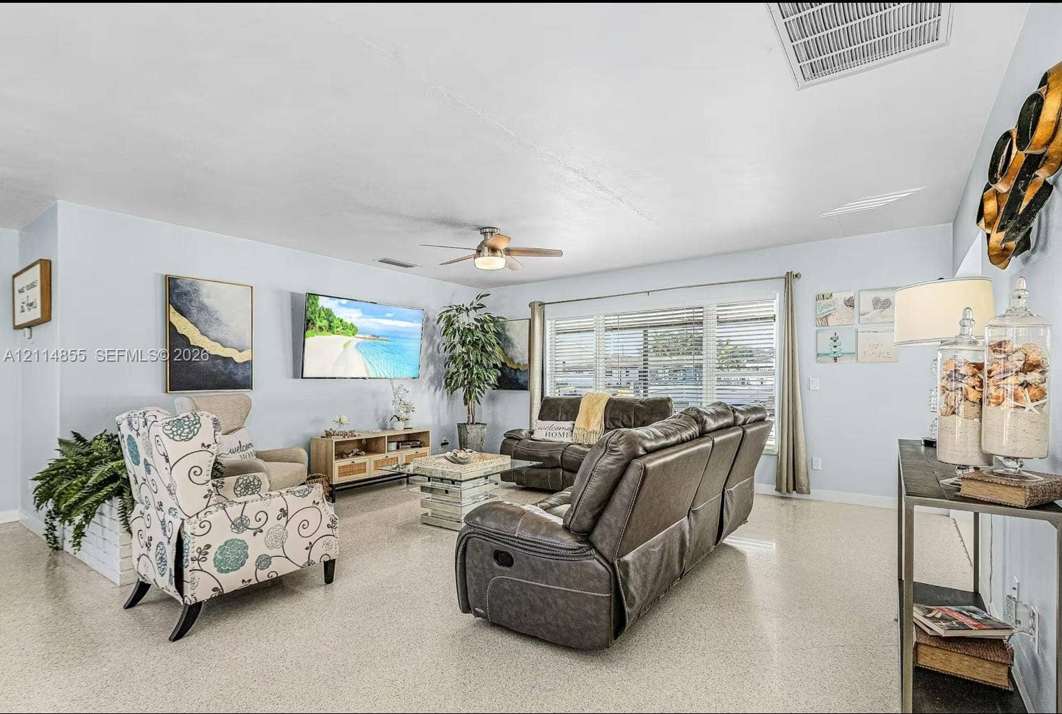 802 Montclair Court, Cape Coral, FL 33904 Living area featuring large format terrazzo flooring, multi-pane window with horizontal blinds, and ceiling-mounted fan with integrated light fixture
