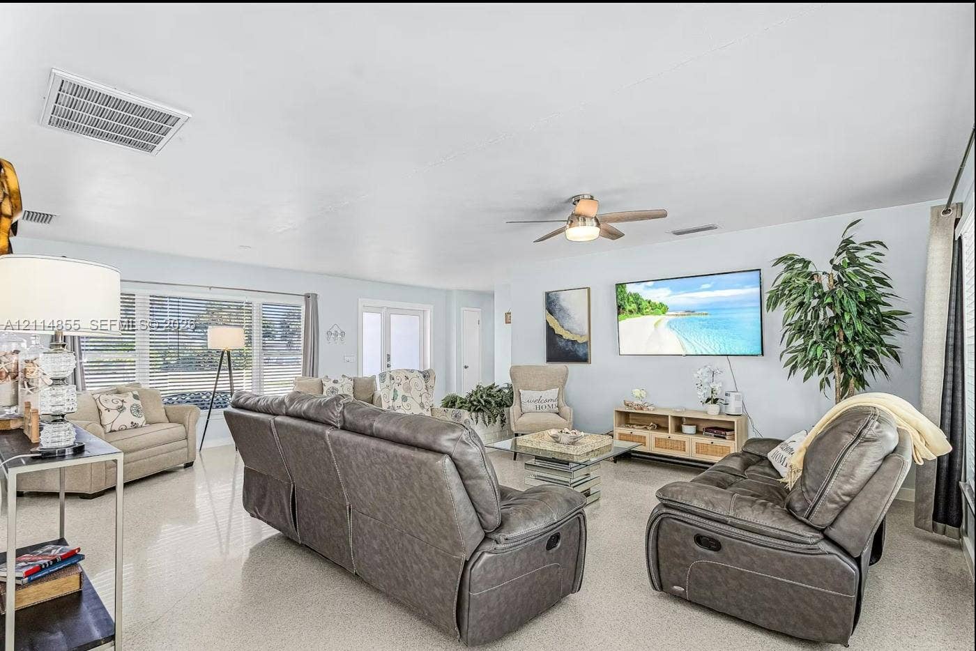 802 Montclair Court, Cape Coral, FL 33904 Living area featuring large-format tile flooring, a ceiling fan with integrated lighting, and expansive windows