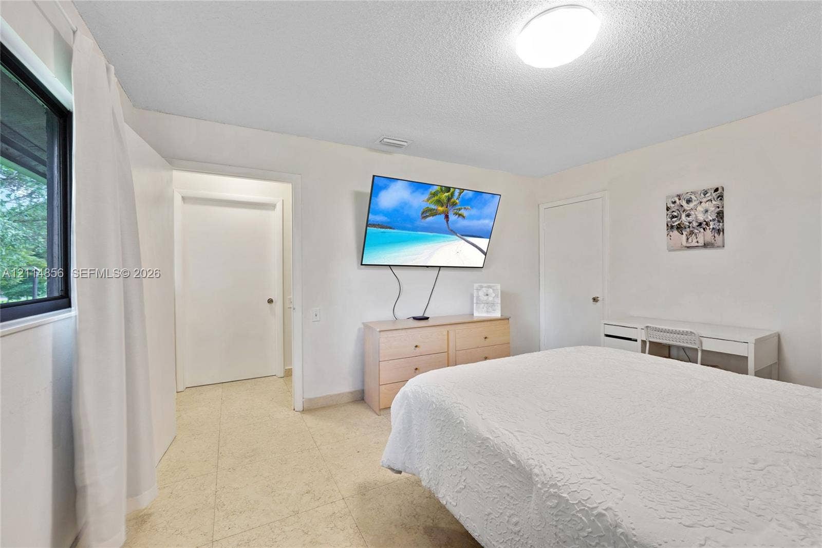 Miami, FL 33173 Neutral interior featuring light-toned stone-finish flooring, a large window, and flush-mount ceiling lighting