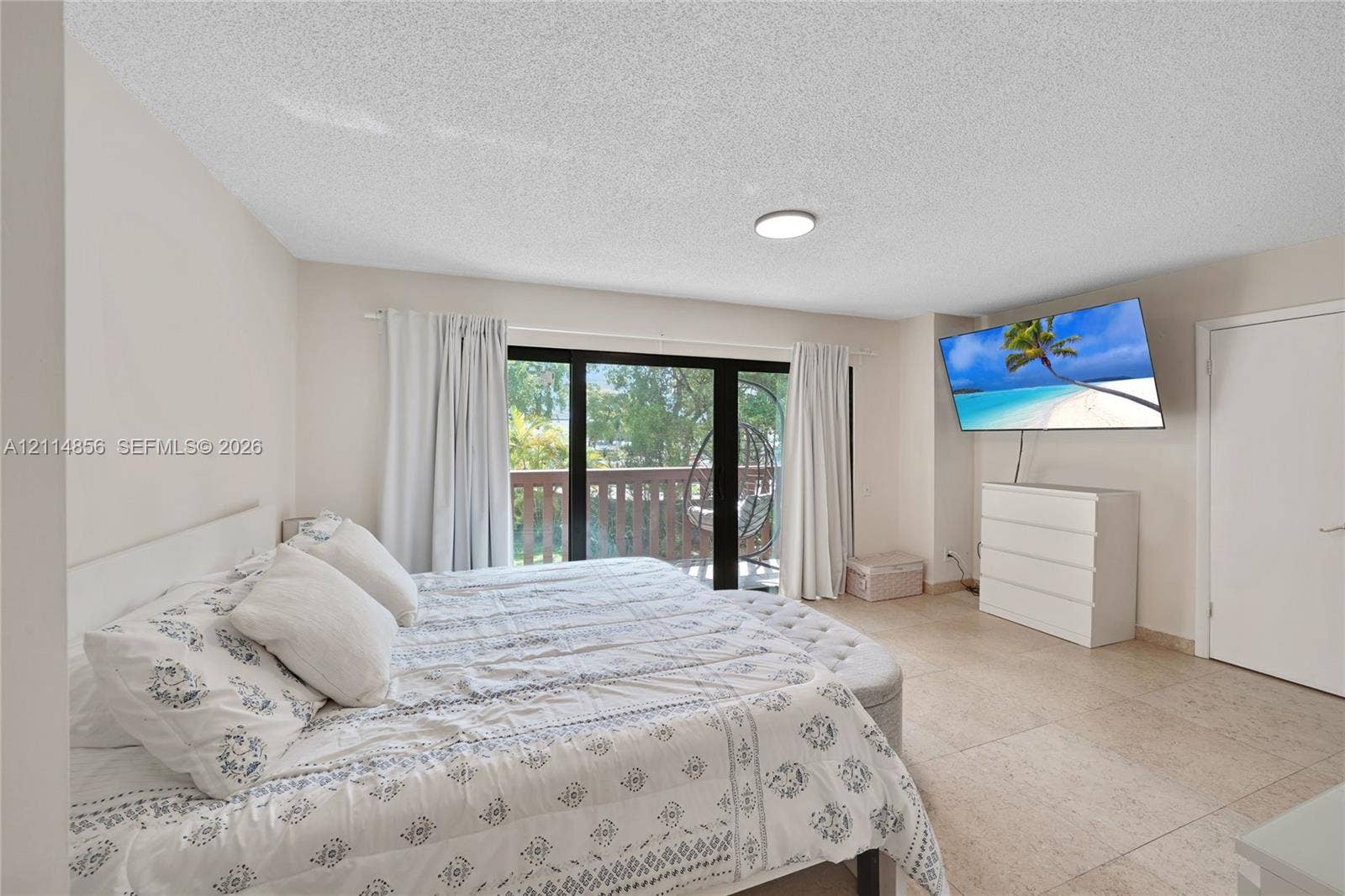 Miami, FL 33173 Interior space featuring neutral wall paint, large-format tile flooring, a flush-mount ceiling light, and sliding glass doors with access to an exterior wooden deck