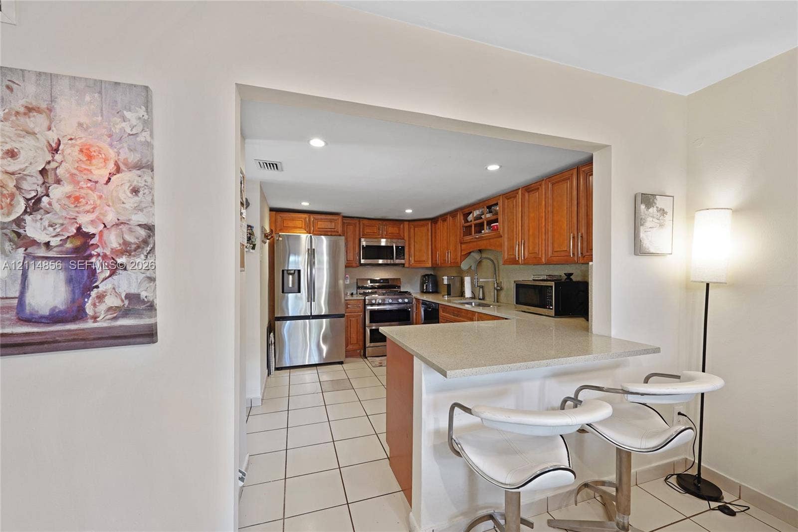 Miami, FL 33173 Kitchen featuring wood cabinetry, stainless steel appliances, solid surface countertops, and tiled flooring
