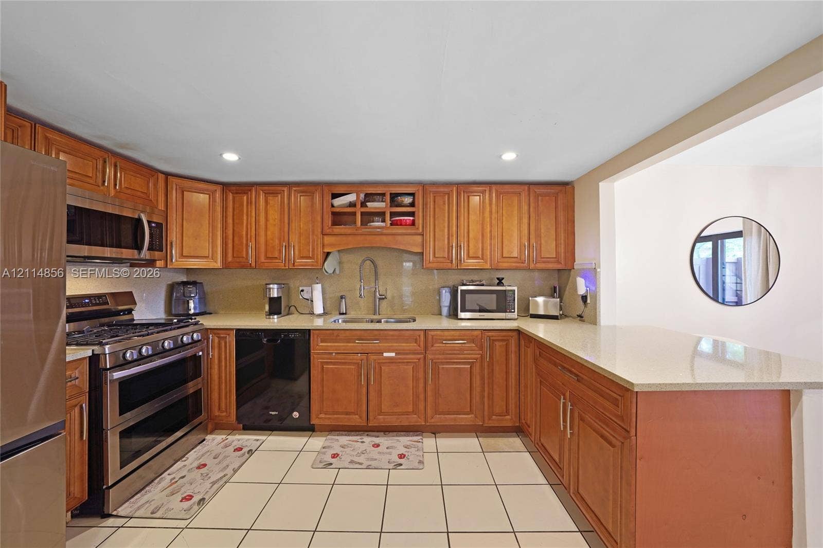 Miami, FL 33173 Kitchen featuring wood cabinetry, stone countertops, a stainless steel gas range, and ceramic tile flooring